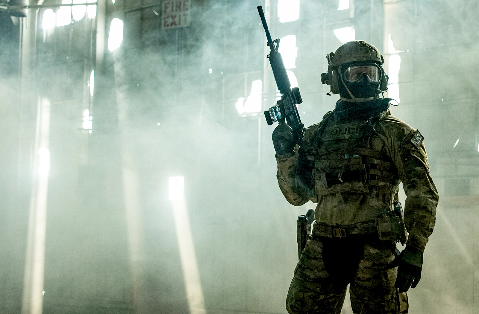 A male model wearing military/police uniform while holding a Simunition training weapon